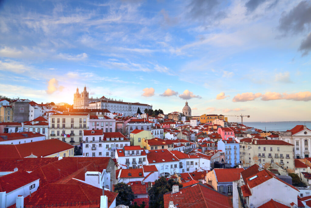 Ausblick über die Dächer von Lissabon bei Sonnenuntergang – Symbol für Neubeginn und Freiheit im Auswander-Coaching von Sail Your Life.