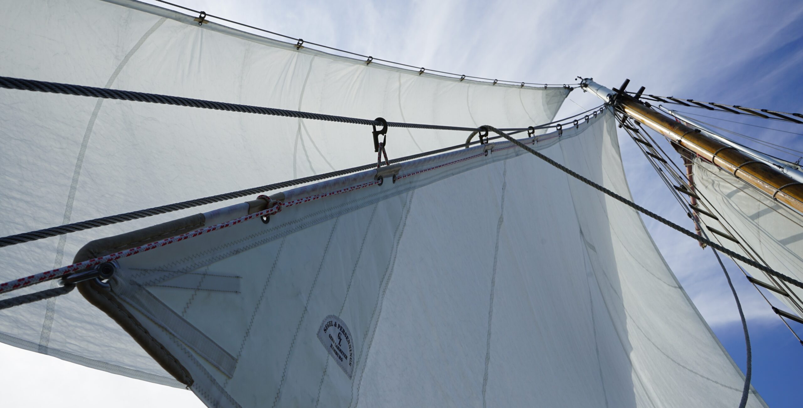 Nahaufnahme gesetzter Segel eines Segelbootes vor blauem Himmel – Symbol für Aufbruch, Klarheit und Selbstführung im Sail Your Life Coaching.