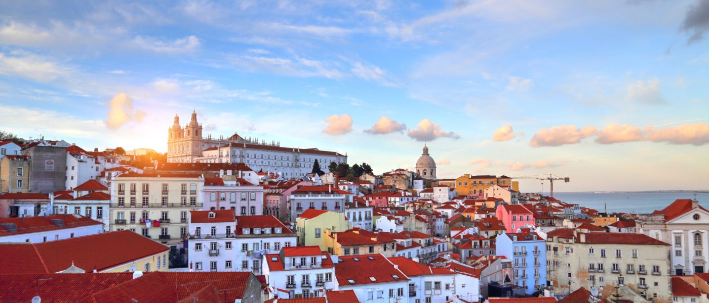 Ausblick über die Dächer von Lissabon bei Sonnenuntergang – Symbol für Neubeginn und Freiheit im Auswander-Coaching von Sail Your Life.